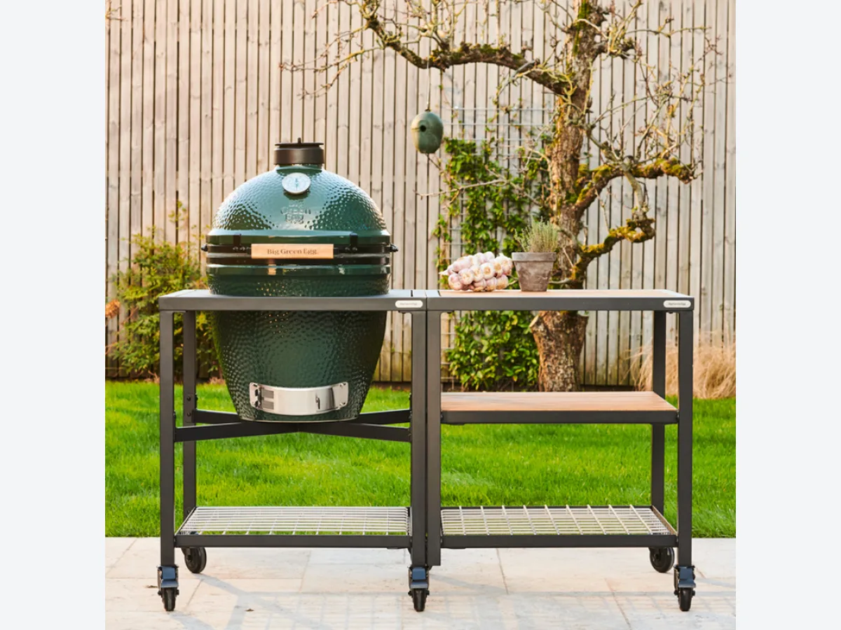 Big Green Egg Modular EGG Workspace, EGG Frame met Big Green Egg en Expansion Frame met rvs en houten inlegbladen op een gazon