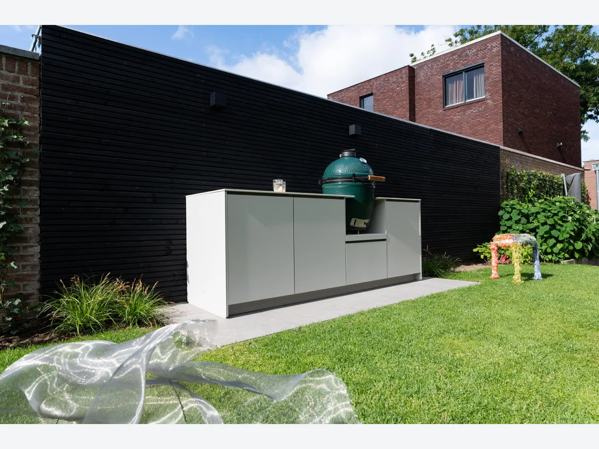 COOXS Concepts, Concepts buitenkeuken in lichte kleur met Big Green Egg tegen een zwarte houten wand in een tuin in Nijmegen