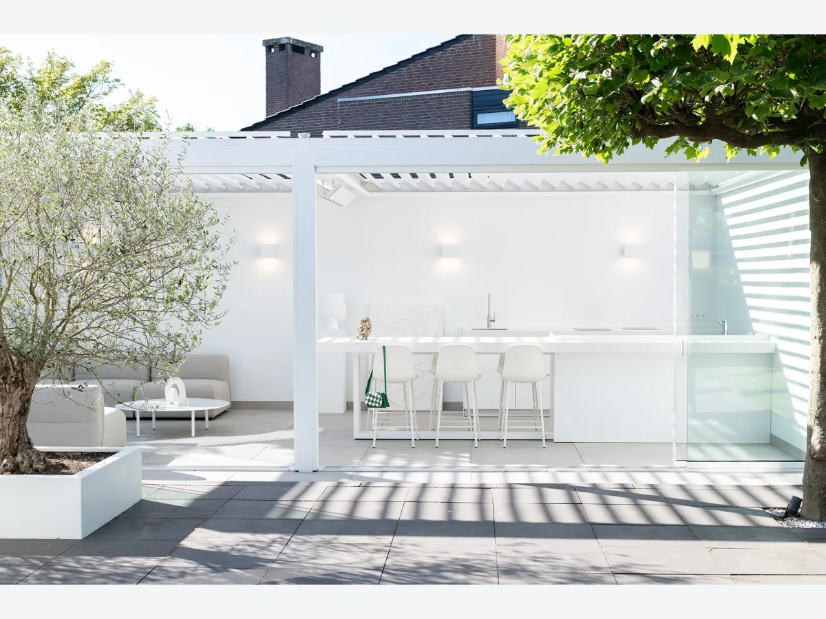 COOXS Create, Witte maatwerk buitenkeuken met bar en barkrukken in een moderne tuinkamer in Alblasserdam