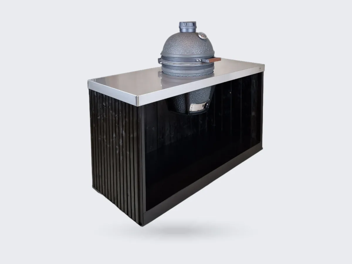 Grill Qube ESSENCE, Grill Qube ESSENCE kamadomodule met stalen frame, zwarte houten latten en rvs werkblad met kamado, driekwart van linksvoor, witte achtergrond