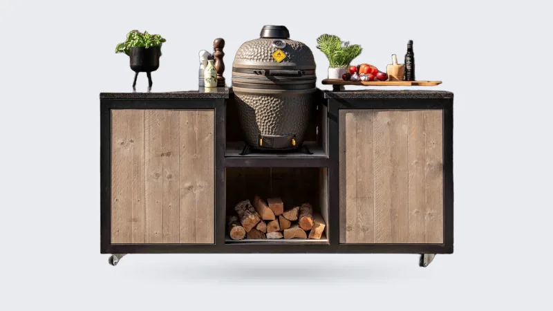 HoutenmeubelsXL Kanawa, Buitenkeuken Kanawa 180 cm met zwart stalen frame, steigerhouten fronten en een kamado in het middenvak, recht van voren voor een bakstenen muur