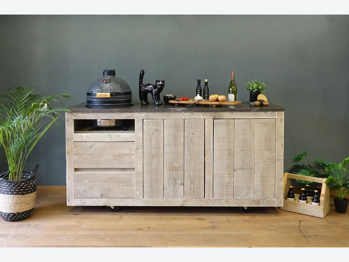 HoutenmeubelsXL Manado Mobile, Buitenkeuken Manado Mobile op wielen met gesloten kamado links, recht van voren voor een groene wand