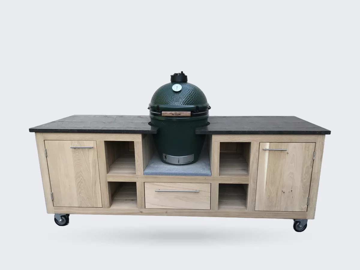 Kamado Buitenkeuken Maatwerk buitenkeuken, Verrijdbare eiken buitenkeuken met donker natuurstenen werkblad, Big Green Egg in het midden, open vakken, lade en deuren voor een witte muur