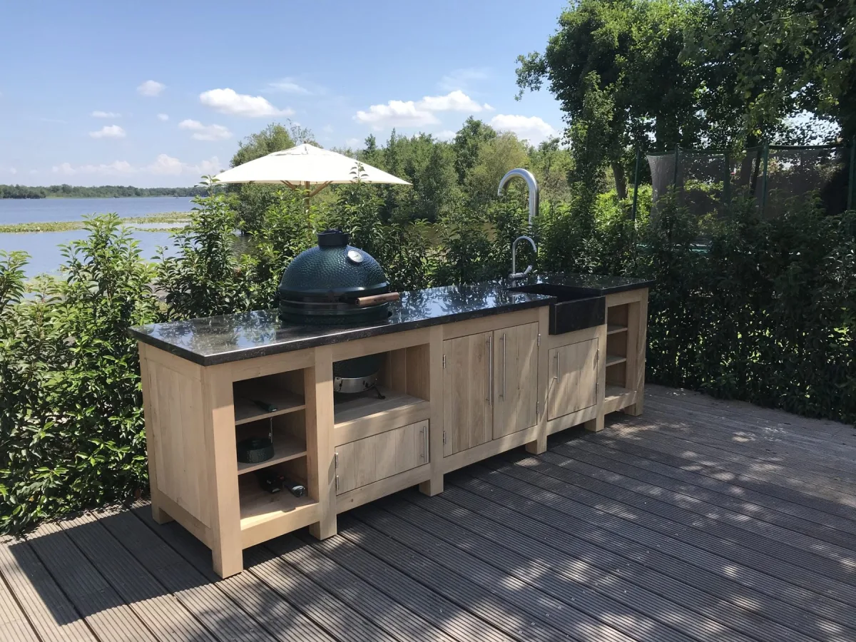 Kamado Buitenkeuken Maatwerk buitenkeuken, Lange eiken buitenkeuken met Big Green Egg, spoelbak met kraan en open vakken op een vlonder aan het water