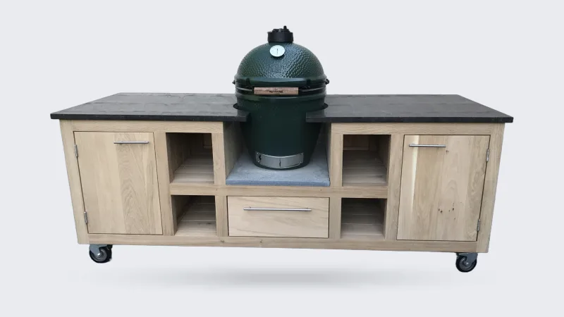 Kamado Buitenkeuken Maatwerk buitenkeuken, Verrijdbare eiken buitenkeuken met donker natuurstenen werkblad, Big Green Egg in het midden, open vakken, lade en deuren voor een witte muur
