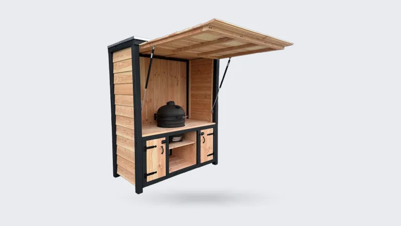 Maison DAM Douglas deluxe met klep, Douglas buitenkeuken deluxe met geopende klep, zwart frame en kamado, driekwart van linksvoor voor een donkere loods