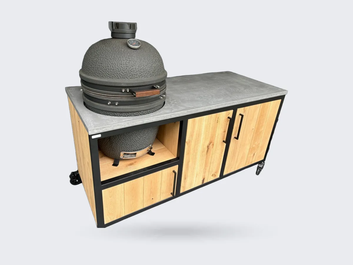 MB Industrial Living Basic, Buitenkeuken Basic met zwart stalen frame, eiken fronten en grijs Mortex werkblad, kamado links en twee houten deuren, driekwart van linksvoor op een overdekt terras