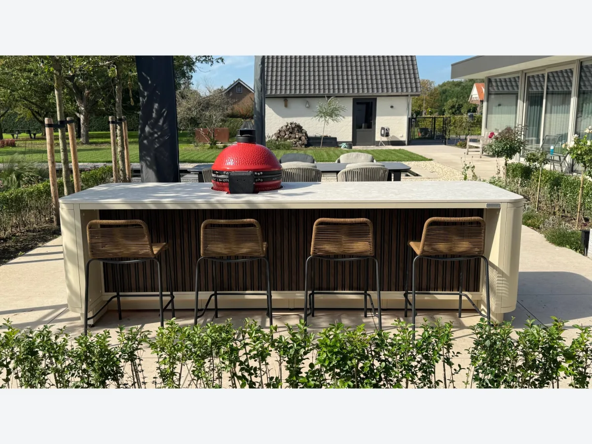 Rêveluxe Création, Création Prestige Oval in beige met rode Kamado Joe en barkrukken in een groene tuin, project Elst