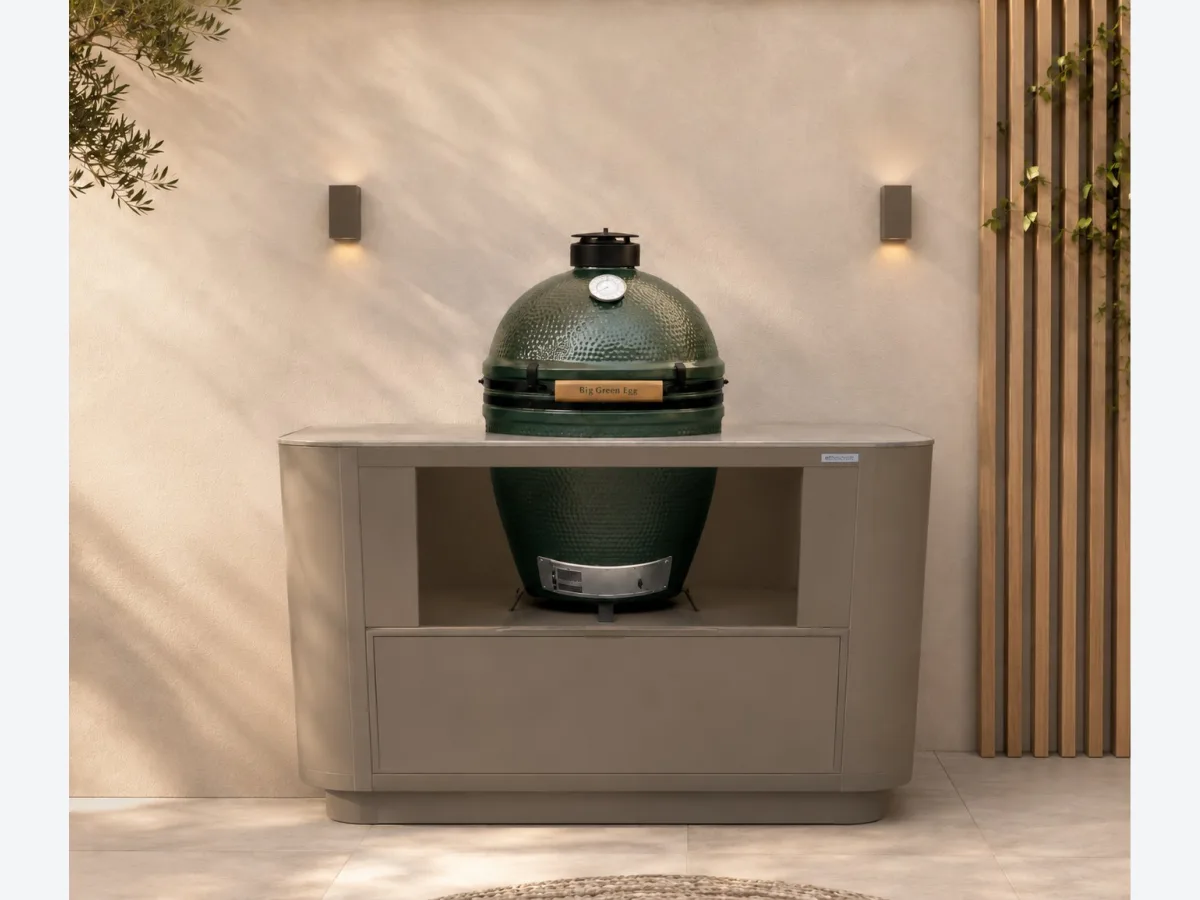 Rêveluxe Origine, Render van een Origine buitenkeuken in taupe met Big Green Egg tegen een lichte stucwand met wandlampen (1362 px breed, groter niet op de site)