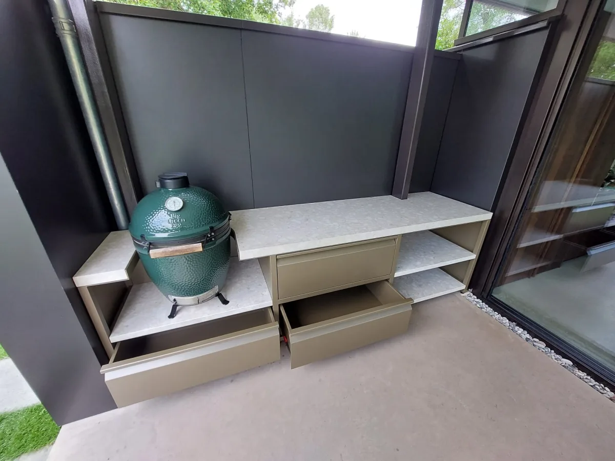 Robuust Maatwerk Vaste buitenkeuken, Vaste buitenkeuken van gecoat staal en keramiek met Big Green Egg Large, lades en open vakken, driekwart van rechtsvoor