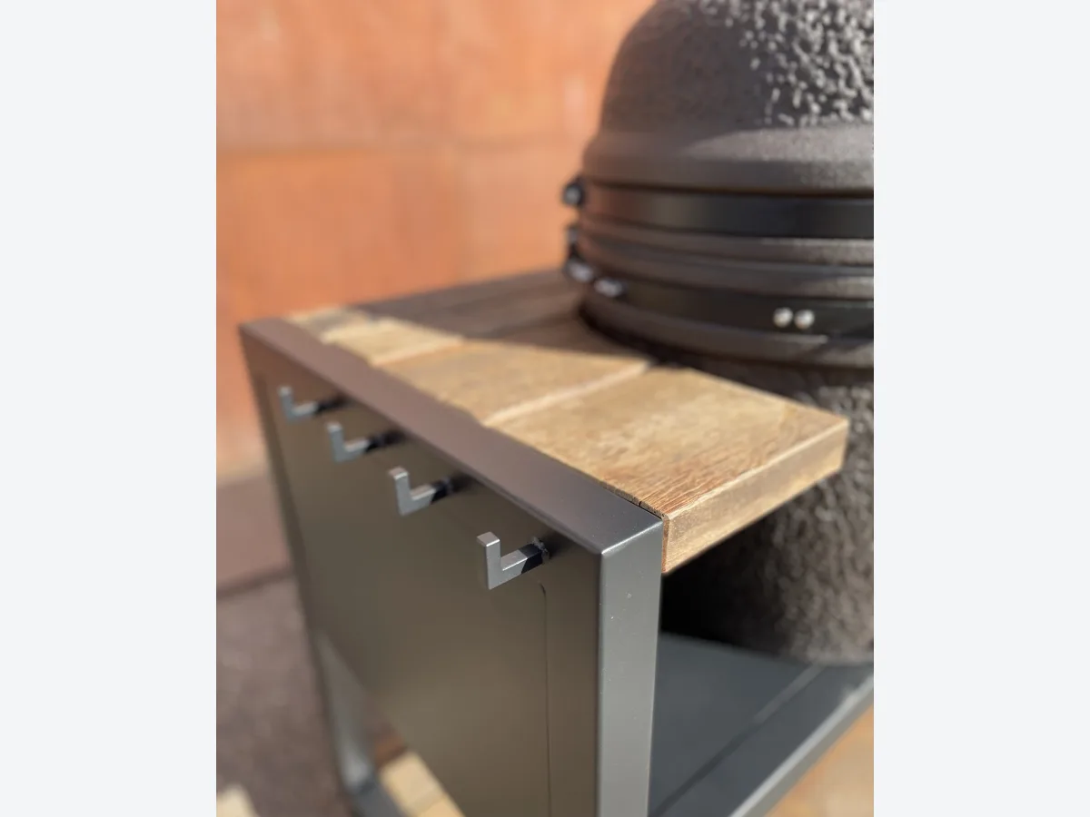 Robuust Maatwerk Verrijdbare buitenkeuken, Detail van de kamado in de uitsparing van het azobe blad, met de grillhoogte gelijk aan het werkblad en haakjes aan de zijkant