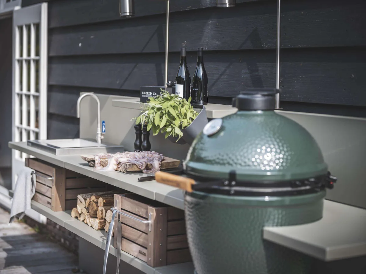 WWOO Staal, Detail van de WWOO stalen buitenkeuken in groen met Big Green Egg, spoelbak, snijplank en houten kratten